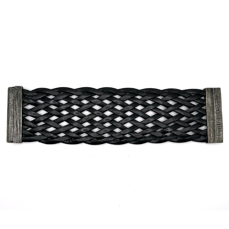 Wide cuff bracelet of braided black Italian leather, laid open flat to show the signature Cynthia Desser gunmetal magnetic clasp.