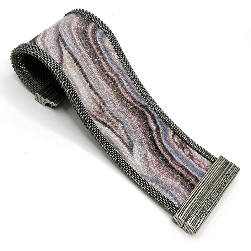 Wide cuff bracelet with oxidized silver mesh framing a multi-color Botswana agate slice pattern highlighted by shiny and matte Swarovski micro-crystals, open with one end curled under to show off the signature Cynthia Desser magnetic clasp, on a white background.