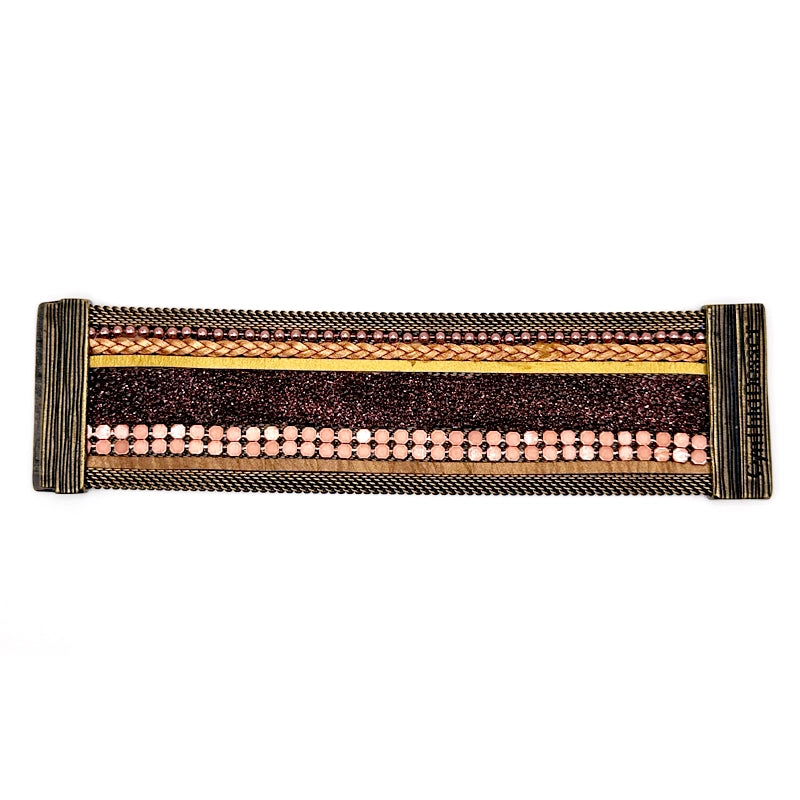 Wide cuff bracelet with a mix of copper colored metal elements, metallic gold leather braids or strips, and pink-brown shimmery stingray, with brass mesh edges, laid open flat to show signature Cynthia Desser magnetic clasps, on a white background.